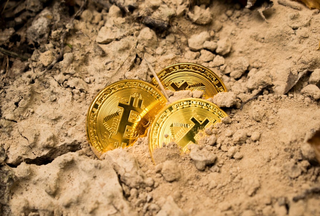 Bitcoins half hidden in dirt